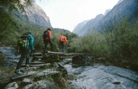 A group of hikers crossing a bridge over a river