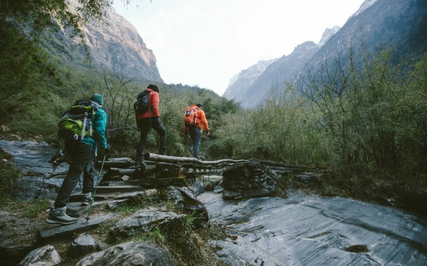 A group of hikers crossing a bridge over a river